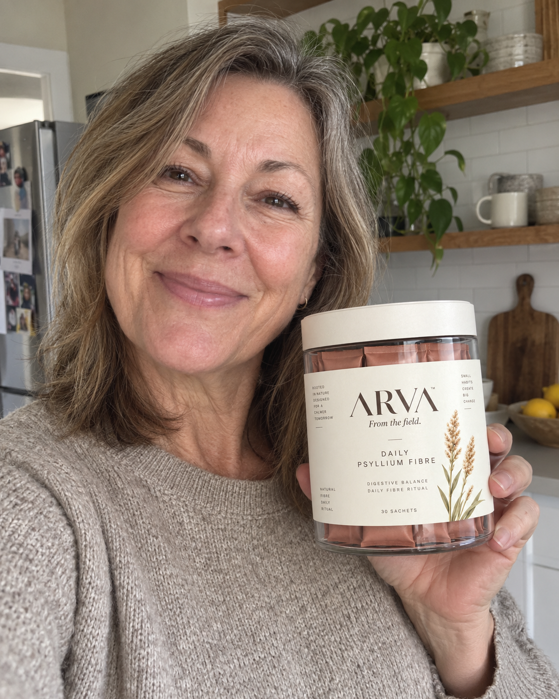 Woman in her kitchen holding a jar of Arva