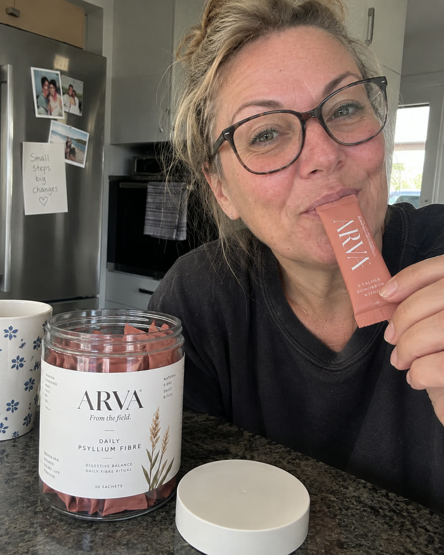 Woman in her kitchen holding a jar of Arva Daily Psyllium Fibre